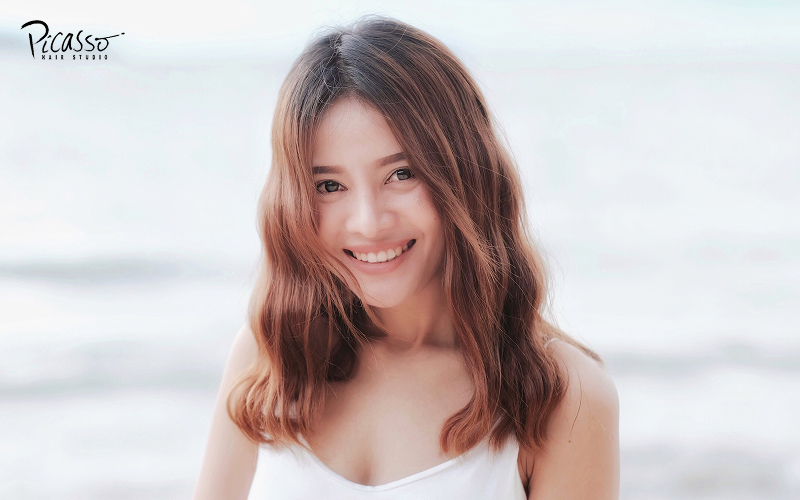 Woman smiling with a beach-wave perm.